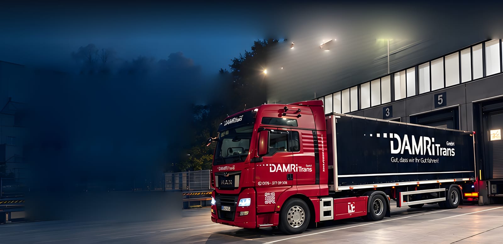 Roter DAMRiTrans-Sattelzug mit schwarzem Auflieger bei Nacht an einer Laderampe