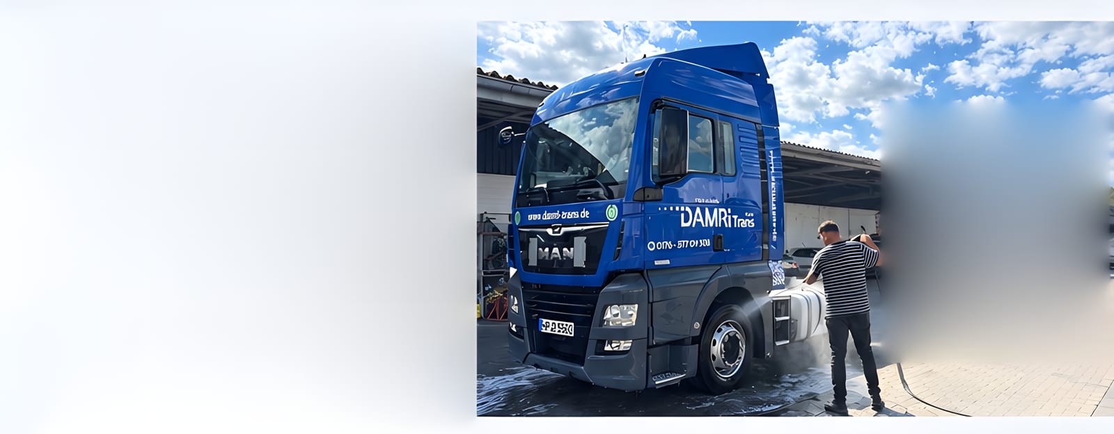 Blaue DAMRiTrans-Sattelzugmaschine wird auf dem Betriebshof gewaschen